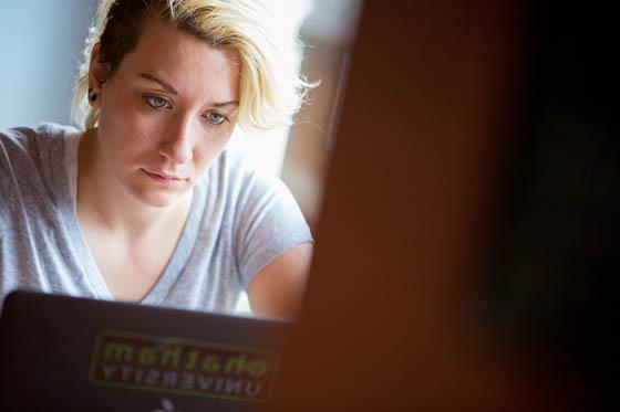 Photo of a Chatham University student looking at her laptop in Cafe Rachel.