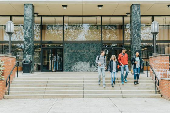 图为四名波胆网站学生离开位于夏德赛德校区的图书馆.
