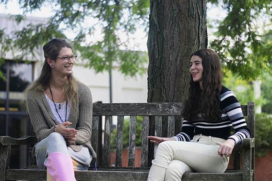 学生和成功教练在长椅上谈笑风生的照片